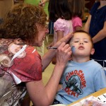 Local artist Nancy Haack paints a spider on Taydan Winters, 4, a Headstart student at Prospect Street Preschool. Haack donated her time talent to give all the Headstart students a special treat. She will also give free face painting to Headstart students at her Duck Day booth.