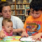 Alivia Ruggiano, 9 months, helps her older brother, Robbie Ruggiano, 5, decorate a mask as their mother, Sarah Ruggiano, watches over July 14 at the Beacon Falls Public Library.