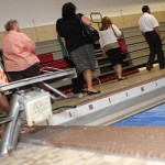 Members of the Board of Education, Board of Finance, and Board of Mayor and Burgesses walk through the pool at Naugatuck High School during a tour Aug. 25. Renovation plans for the building would move the bleachers to an upper balcony and bring the pool up to code.