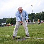 Athletic Director Tom Pompei points to a drain on the edge of the Naugatuck High School soccer field. Drains and sprinklers in the field violate safety codes for players.